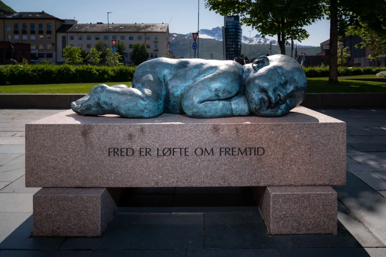 Bilde at statuen "Fred er et løfte om fremtid" Sovende baby på en steinblokk.