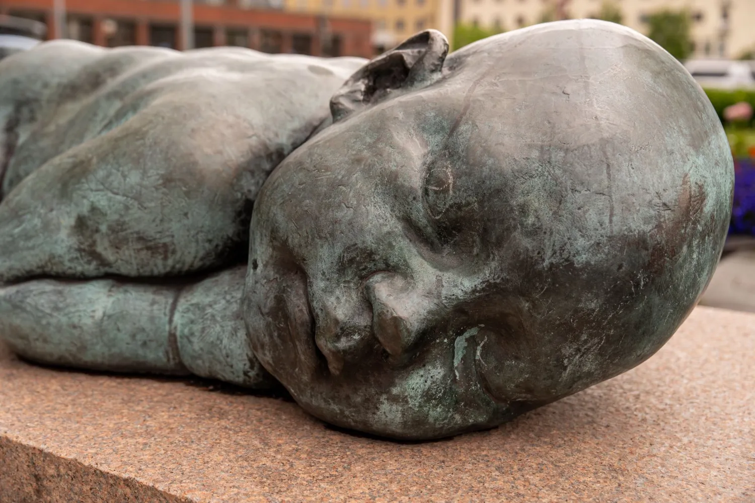 Nærbilde at statuen "Fred er et løfte om fremtid" Sovende baby på en steinblokk.