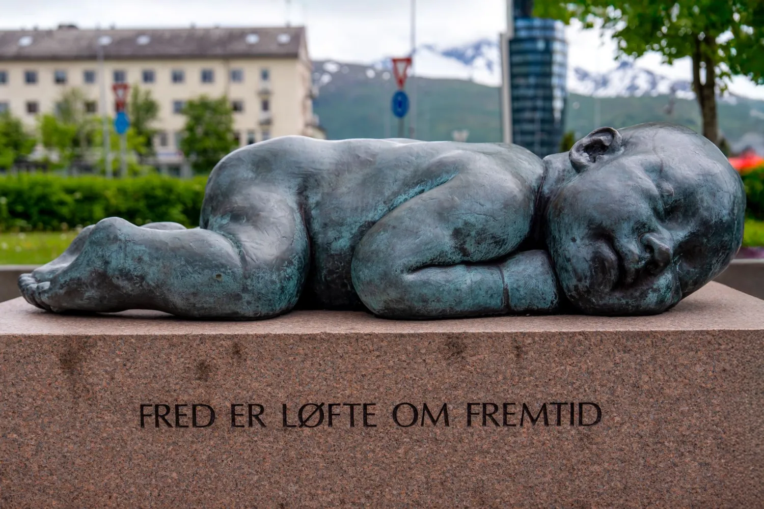 Bilde at statuen "Fred er et løfte om fremtid" Sovende baby på en steinblokk.